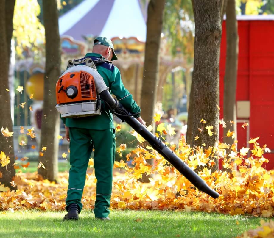 a man using a leaf blower in a park